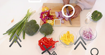 Chopping cook's hands in knit sweater prepping veggies on white counter with wood board, chef knife....