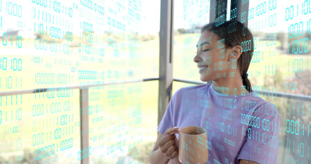 Holding ceramic mug, woman wearing purple tee looking left on porch with copy space. Balcony,...