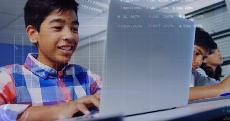 Typing teenage boy wearing blue red white plaid shirt at classroom desks, laptops and data graphics. Students, computers, lab, learning, focus, digital, edtechの写真素材