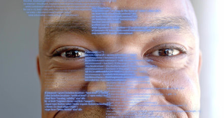 Showing mid-adult man's face filling frame at studio, with blue code projection overlay. Portrait,...
