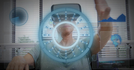 Reaching senior female wearing grey T-shirt interacting with HUD at office lab, with headset. Vr,...