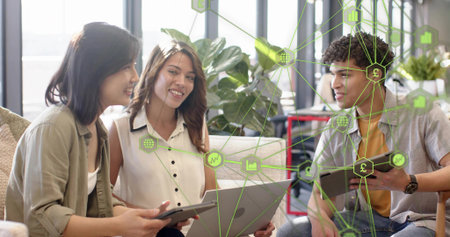 Discussing three coworkers in workwear at coworking lounge, using laptop, tablets, data overlay....