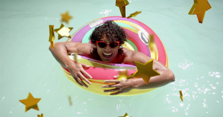 Leaning man in swimsuit, red sunglasses, smiling and floating in sunny pool with donut, stars....