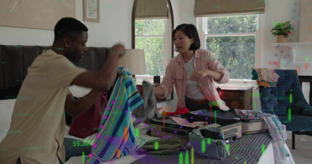 Packing couple in casual clothing handling striped towel and organizing open suitcase in bedroom....