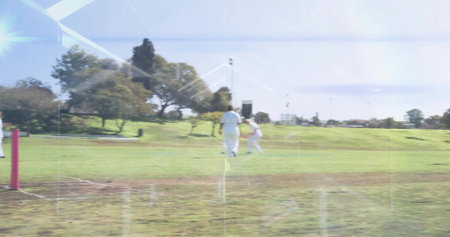 Bowling and batting players in white cricket uniforms moving on cricket ground, with red stumps....