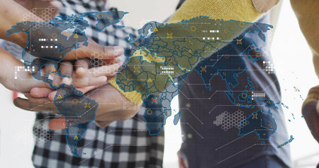 Joining team hands forming stack in office, with checkered sleeve, yellow knit, global map....
