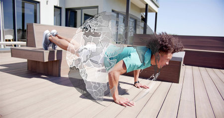Holding plank, athletic man pushing on sunlit rooftop bench, wearing teal tee, shoes, globe overlay....