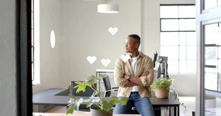 Sitting man crossing arms on desk in open office wearing beige shirt. Modern, minimalist, bright, airy, coworking, workspace, professionalの写真素材