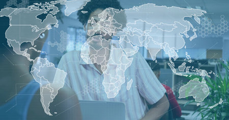 Working man in striped shirt and glasses typing on laptop at office with digital map overlay. Data,...