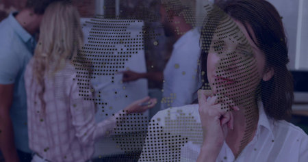 Resting woman in blouse watching team pointing pen at board via dotted world-map glass, copy space. Collaboration, brainstorming, meeting, flipchart, reflection, decal, professionalの写真素材