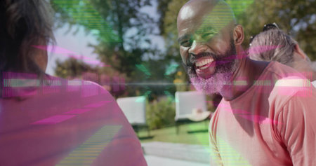 Smiling bearded man wearing pink tee talking at poolside, with lounge chairs. Outdoor, backyard,...