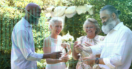 Pouring bearded man filling glasses from bottle, friends in light dresses mingling in sunlit garden....