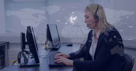Typing woman in blazer headset sitting office using dual screens keyboard map overlay, copy space....