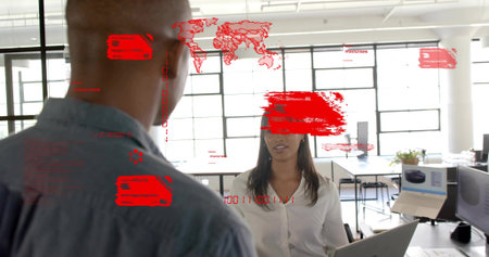 Discussing woman in white blouse using laptop in open office with monitors and red HUD overlays....