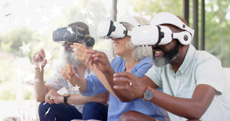 Reaching three seniors wearing VR headsets, shirts on couch in living room showing star AR graphics....