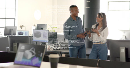 Dev in dark shirt and designer in white discussing in open office, showing monitors, code overlay....
