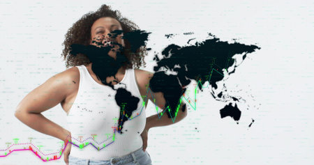 Standing woman hands-on-hips wearing white tank, jeans in studio, showing map overlay and charts. Global, data, analytics, visualization, glitch, digital, futuristicの写真素材