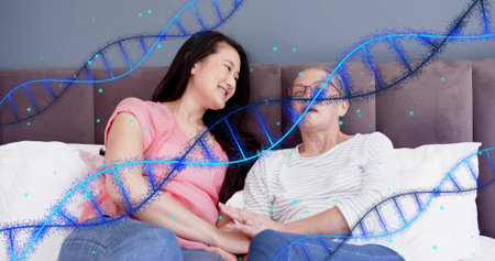 Holding hands, daughter in pink top leaning toward mother with eyeglasses on bed with DNA overlay....