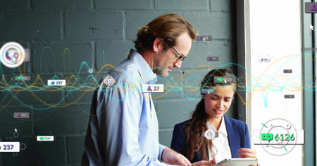 Leaning man glasses blue shirt and woman navy blazer viewing tablet at office window, data overlays....