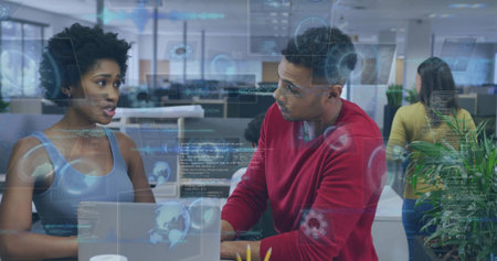 Discussing code, woman in blue tanktop and man in red sweater at office, laptop, AR overlays....