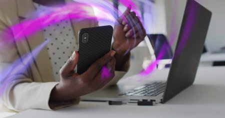 Using black phone, woman in cream blazer, dotted top gesturing at office with laptop, purple trails....