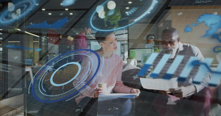 Reviewing documents woman in pink sweater leaning toward gray-haired man at office with AR overlays....