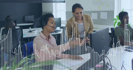 Headset woman in pink blouse gesturing at screen in open-plan office, graph overlay, copy space....