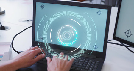 Typing adult hands wearing long-sleeve shirt on laptop keys at white desk, HUD graphic and monitor....