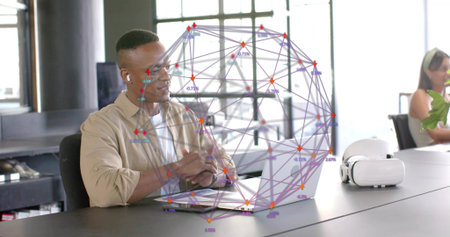 Working man in beige shirt using laptop in modern office, with AR overlay and VR headset....