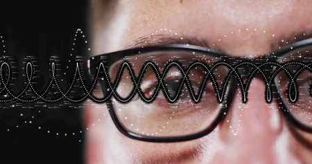 Showing adult male focusing eye region in studio, black eyeglasses with dotted waveform reflections....
