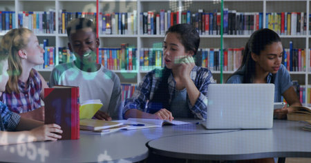 Sitting students in casual clothing discussing schoolwork at school library, with laptop and books....