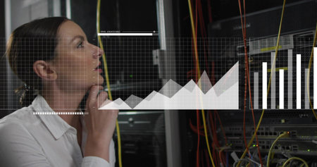 Observing tech in white top studying racks in server room with data overlays, cables, copy space....