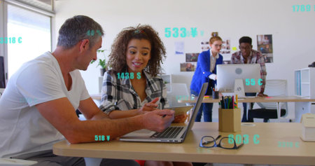 Working team in white tee, checked shirt leaning over laptop and phone at office, teal graphics....
