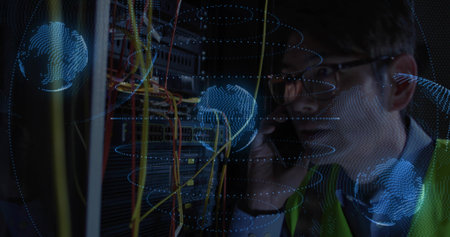 Holding phone, tech with glasses and safety vest fixing server rack in data center with cables....