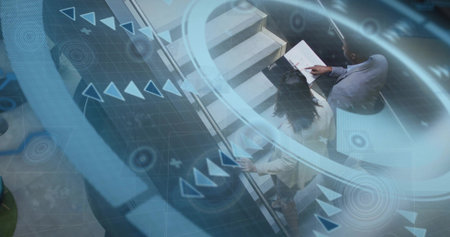 Reviewing colleagues on escalator in lobby, dark-suited man pointing at folder with HUD, copy space....