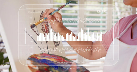 Painting artist applying paint on easel at home wearing white apron holding palette, copy space....