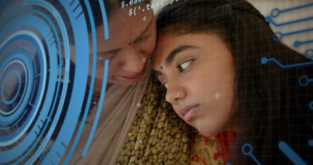 Leaning mature mother and adult daughter sharing quiet home moment, with bindi, shawl. Closeup, intimate, family, bond, sari, traditional, overlayの写真素材