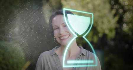 Smiling mature woman in garden, light shirt and hoops. Outdoor, greenery, portrait, female, backyard, bokeh, sunlitの写真素材