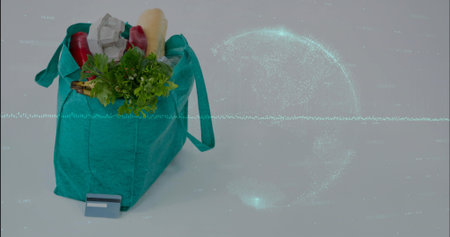 Sitting teal grocery bag holding baguette, card on studio table with data globe overlay, copy space....