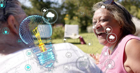 Laughing senior woman wearing pink top, shades, chatting on lawn by chair bulb icons, copy space....