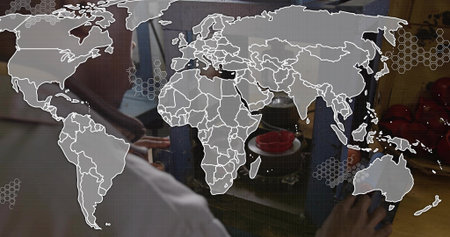 Leaning technician in white coat adjusting blue guide on counter, red tomato bowls and map overlay....