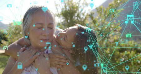 Hugging senior woman, child kissing cheek and leaning in yard, in tank tops, teal network icons....