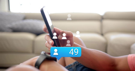 Holding smartphone, man wearing pink shirt tapping on light sofa with smartwatch and '49' overlay....