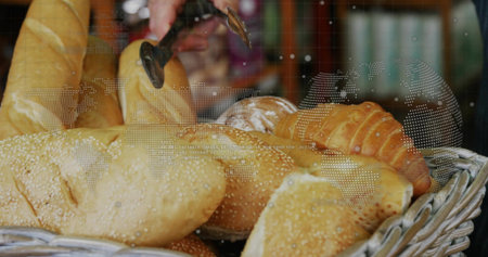Lifting dark-sleeved hand using metal tongs removing sesame roll from bakery basket, map overlay....