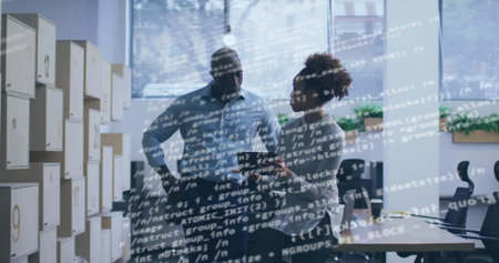 Discussing man in shirt, woman in blouse pointing tablet in office, code overlay, numbered cubbies....