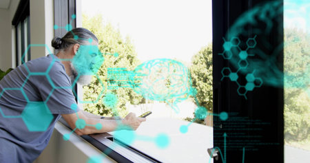 Leaning grey-tee man checking smartphone at sliding window and sill, teal graphics, copy space....