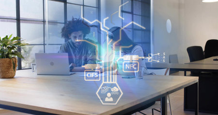 Working two coworkers in casual business reviewing laptop at table with plant, glass, digital icons....