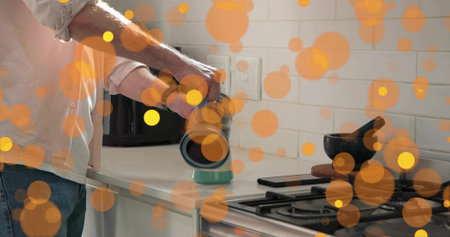 Pressing coffee with cylindrical grinder, man in shirt and jeans at kitchen countertop, copy space....