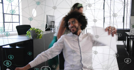 Leaning curly man wearing white shirt holding large sheet in open office, with network overlay....