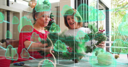 Crafting mother-daughter at home in red and white tops arranging wreaths with green cloud overlay....
